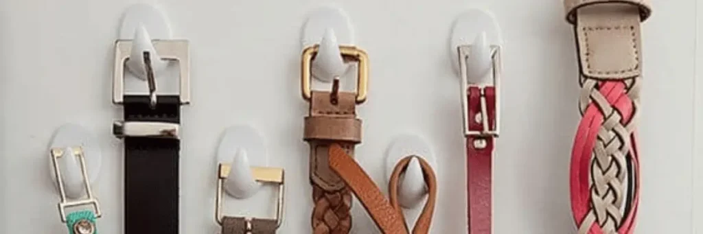 Cintos pendurados por ganchos adesivos